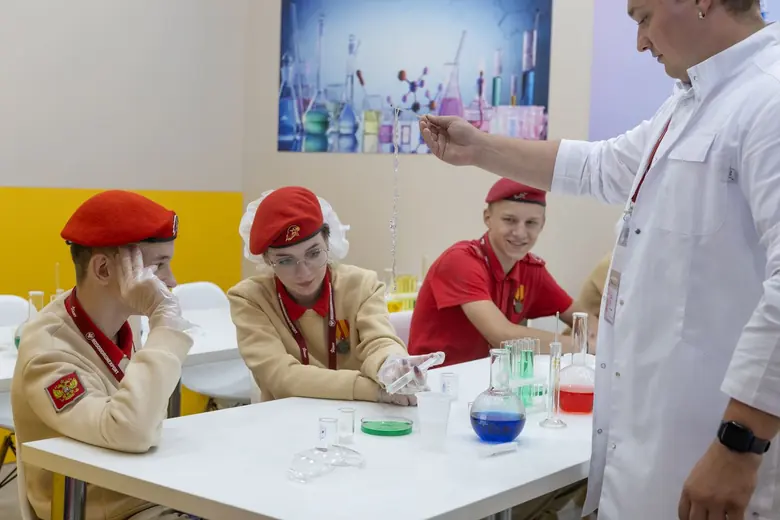 Курсанты в форме за лабораторным столом с ведущим