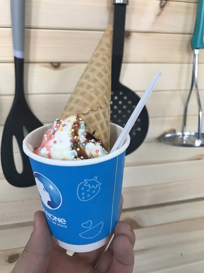 Стаканчик Danone с мороженым в руке