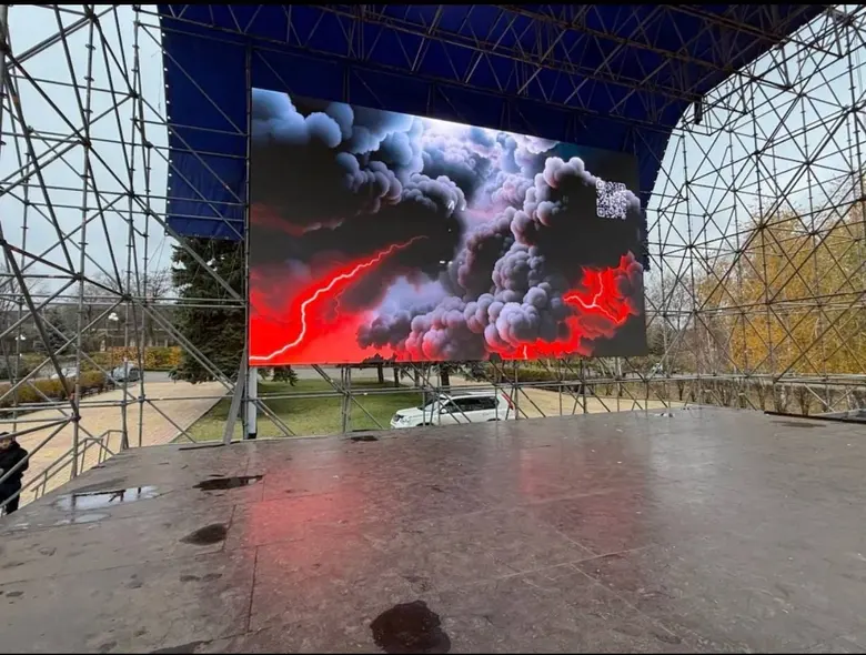 Большой LED-экран на ферме под сценическим навесом: яркая картинка читается днём