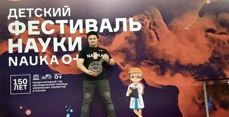 Владислав Саенко показывает опыт ребёнку на фестивале науки